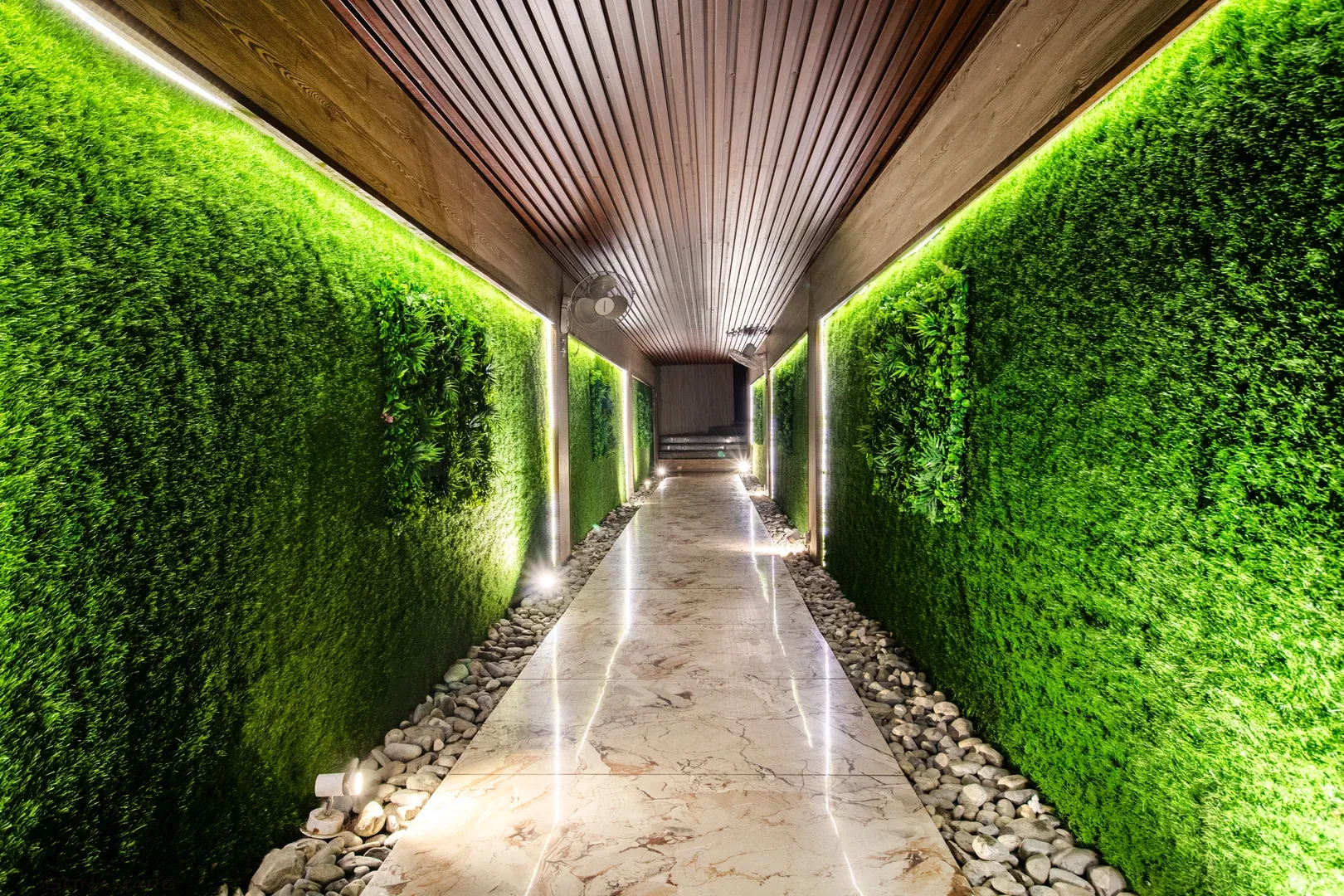 Green hedge corridor under wood paneling.